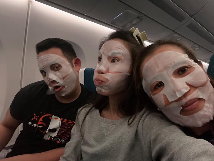 Tony and family wearing sheet masks on the flight to Thailand