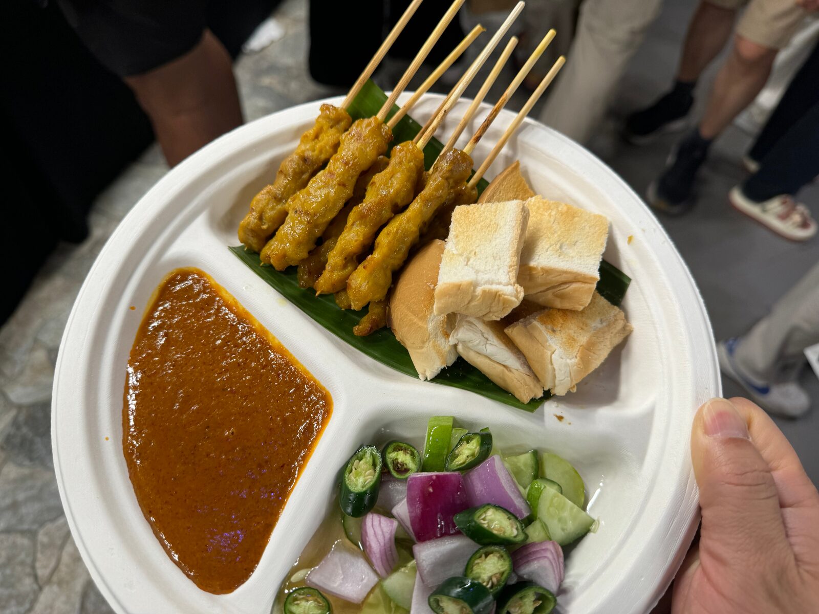 A plate of Thai chicken satay with peanut sauce and cucumber relish