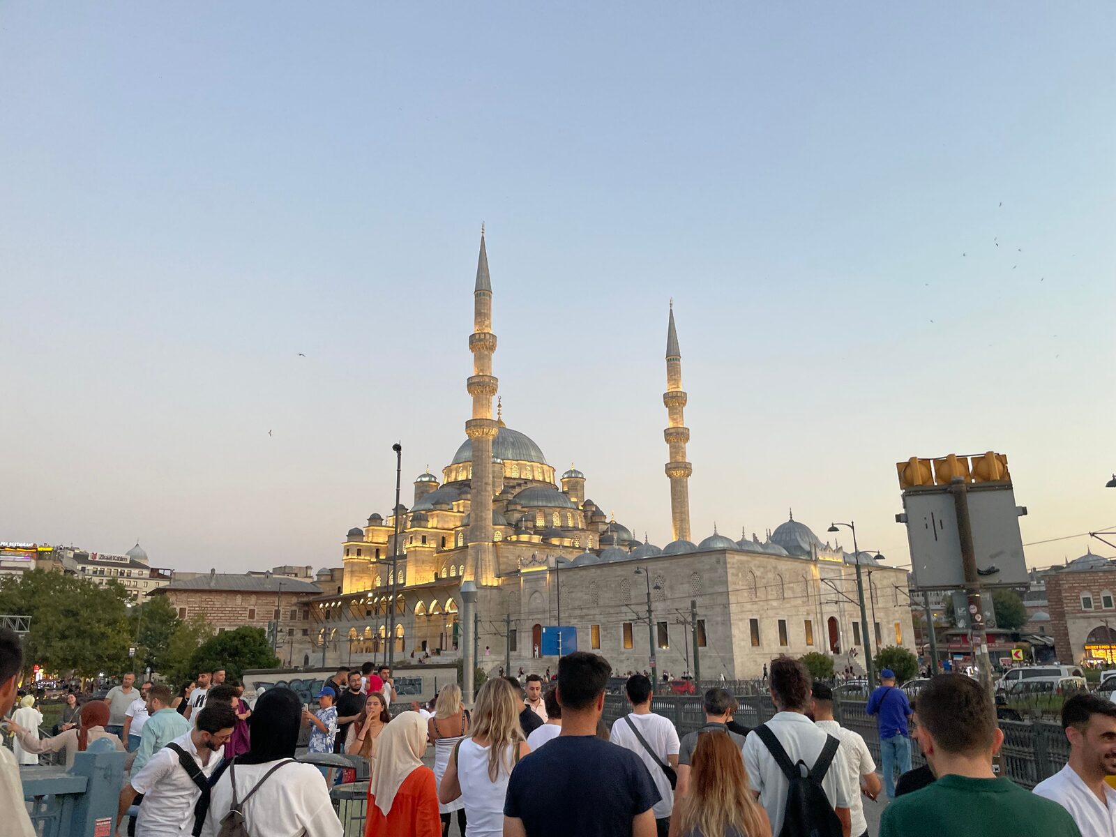 The New Mosque in Istanbul at dusk with crowds on the Galata Bridge