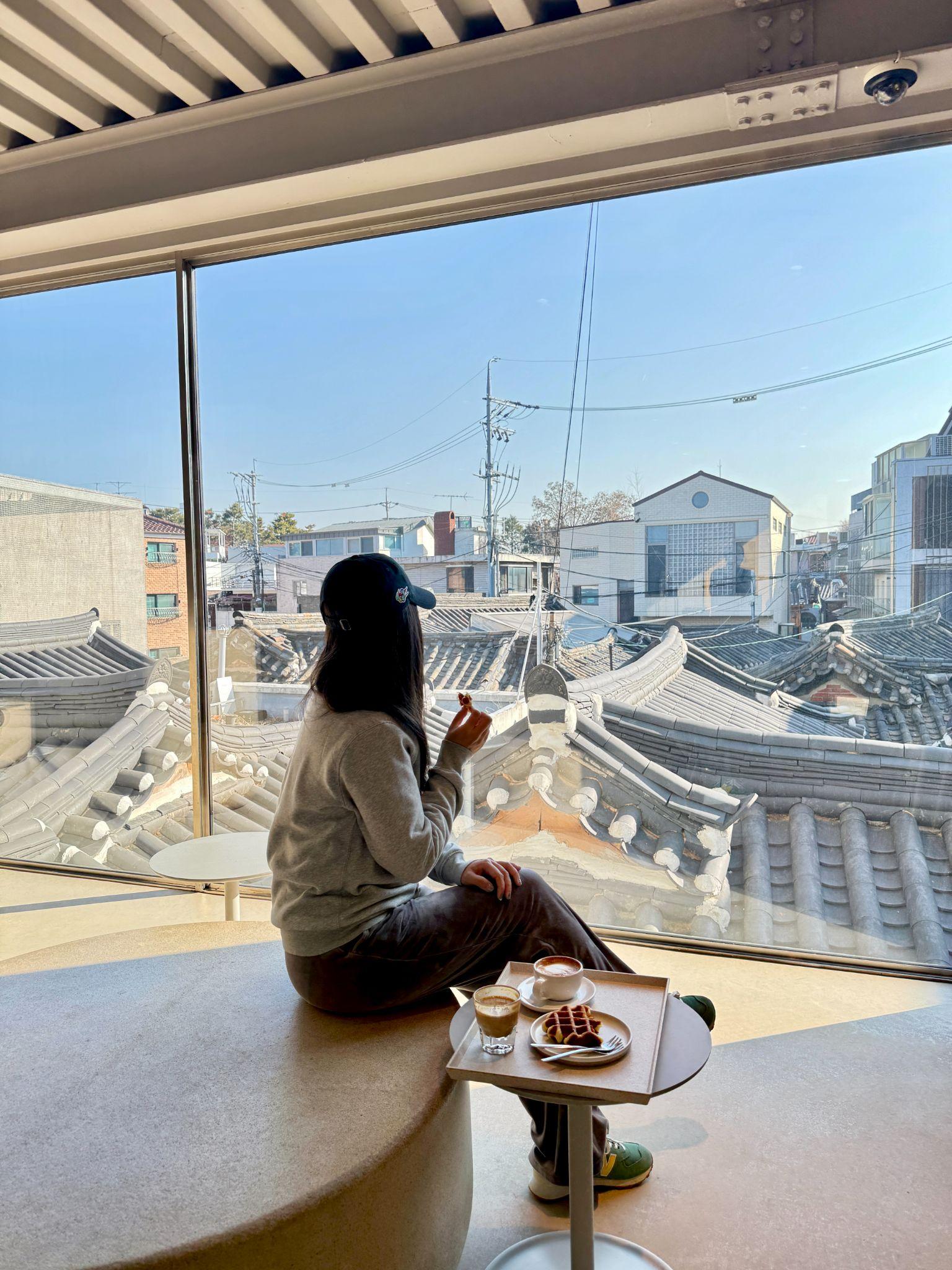 Window seat at a Seoul cafe overlooking traditional Korean tile rooftops