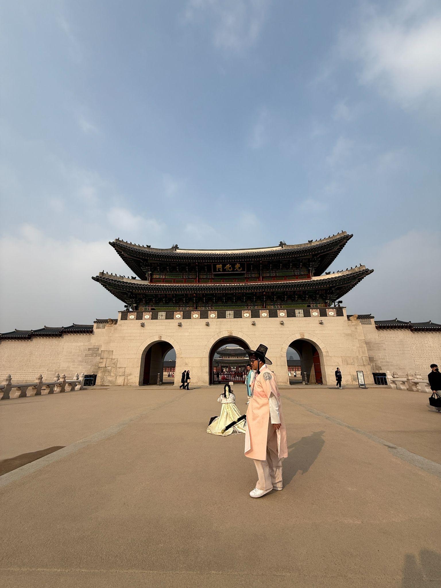 Gwanghwamun Gate at Gyeongbokgung Palace with visitors in traditional Hanbok